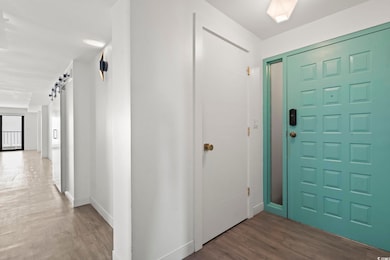 Entrance foyer with a barn door and dark wood-type