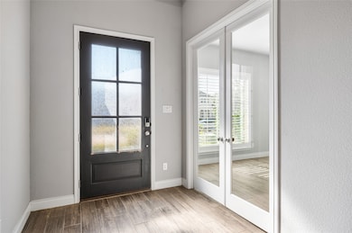 Doorway with french doors and wood finished floors