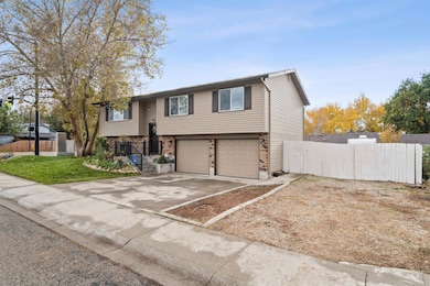 Bi-level home featuring brick siding, driveway, and an attached garage