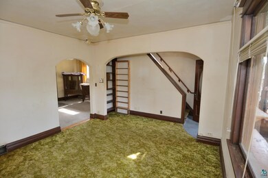 Living room with ceiling fan,book shelf and green 