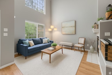 Living area with vaulted ceiling. light wood-style floors and loads of natural light
