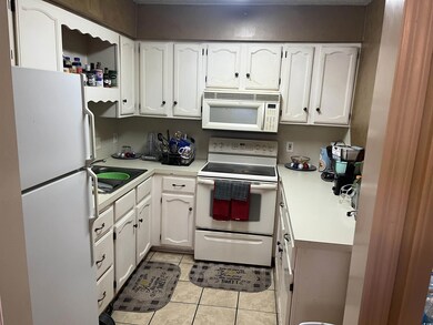 Kitchen with sink, white cabinets, white appliance