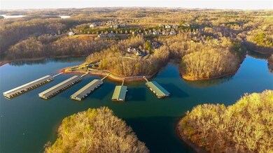Aerial view of property's location featuring a forest and a nearby body of water
