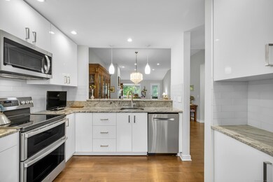 Kitchen with view to dining and living room. Appliances include GE double oven (3 years old), BOSCH dishwasher, Maytag refrigerator, and Whirlpool microwave.