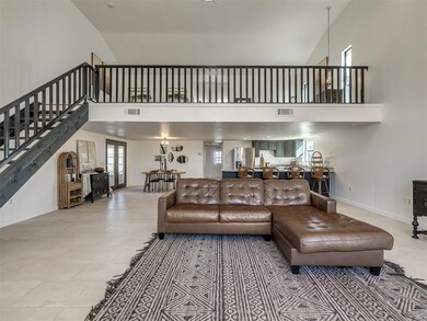 Living room with stairs, a high ceiling, baseboard