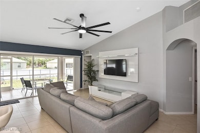 Living room featuring arched walkways, light tile