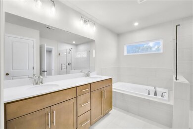 Full bath with a stall shower, a garden tub, double vanity, light tile patterned floors, and recessed lighting