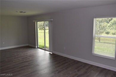 Empty room featuring plenty of natural light and dark hardwood / wood-style flooring