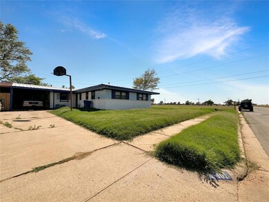 View of side of home featuring a lawn and a carpor