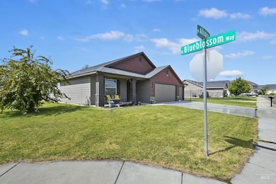 Ranch-style home with driveway, a front yard, a garage, and a shingled roof