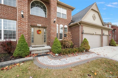 View of front of house featuring concrete driveway, brick siding, roof with shingles, and a front lawn