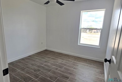 Empty room with wood finish floors and ceiling fan