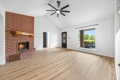 Unfurnished living room with ceiling fan, a brick