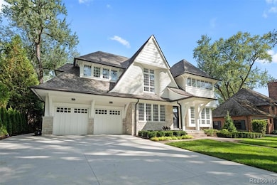 View of front of house featuring stone siding, concrete driveway, a balcony, and a front lawn