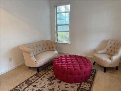 Sitting room with carpet floors and baseboards
