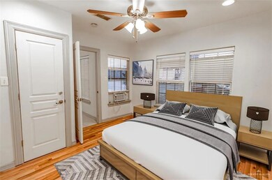 Bedroom featuring ceiling fan, cooling unit, and light wood-type flooring