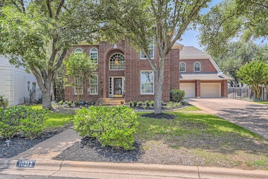 Georgian-style home with fence, brick siding, dri