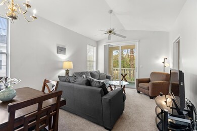 Carpeted living room with vaulted ceiling and ceil