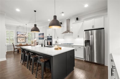 Designer kitchen with quartz counters, oversized island, stainless appliances, and custom pantry.