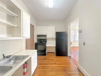 Kitchen with black appliances, light hardwood / wo
