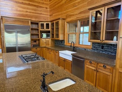 Kitchen featuring decorative backsplash, dark ston