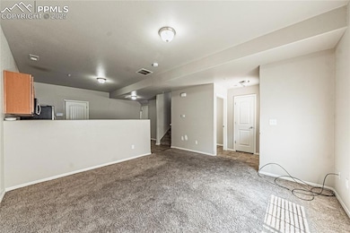 Unfurnished living room with carpet flooring and stairway