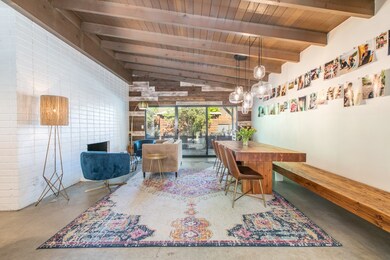 Gorgeous dining/family room with custom built in bench, fireplace, open bean ceilings and polished concrete floors