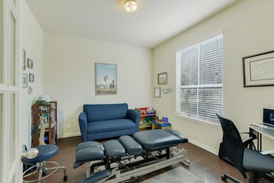 Office space with dark wood-type flooring and baseboards
