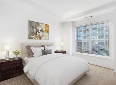 Bedroom with light colored carpet and baseboards