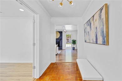 Hall with crown molding, brick flooring, and a chandelier