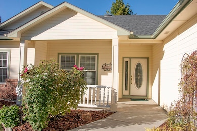 Property entrance with covered porch and roof with shingles