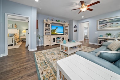 Living area with baseboards, dark wood finished fl