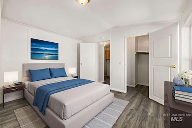 Bedroom featuring dark wood-type flooring and vaulted ceiling