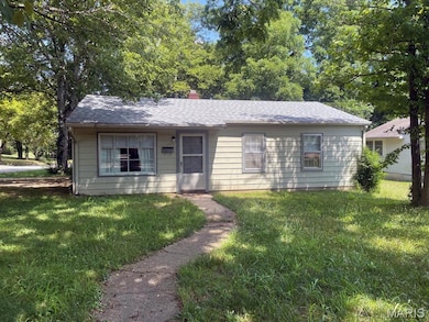 View of front of home featuring a front lawn, a chimney, and roof with shingles