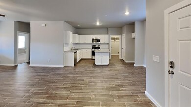 Kitchen featuring white cabinetry, a kitchen island, tasteful backsplash, appliances with stainless steel finishes, and wood finish floors