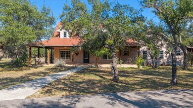 View of front of house with covered porch, a front yard, stucco siding, and a ceiling fan
