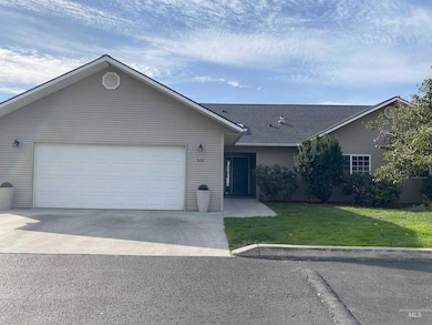 Single story home with a front yard, concrete driveway, a garage, and a shingled roof