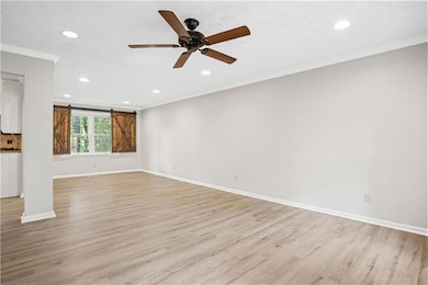 Unfurnished living room with ceiling fan, ornament