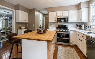 Large kitchen with space for kitchen stools at the butcher block island.