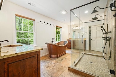 Upstairs Primary suite bathroom featuring dual shower, large soaking tub, double vanities, separate custom closets
