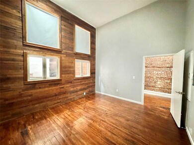 Large Bedroom w/ high ceilings & wood accent wall.