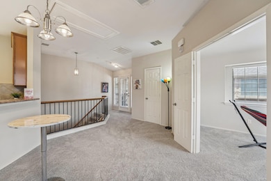 Hall featuring attic access, carpet flooring, an 