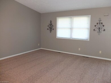 Great room with vaulted ceiling and new carpet.