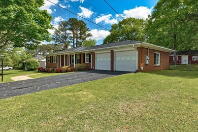 Single story home with a front yard, a garage, aph