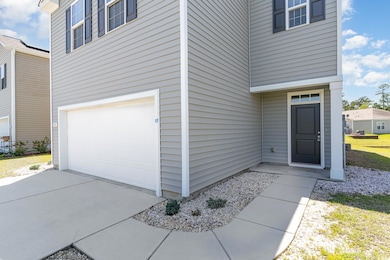 Entrance to property featuring an attached garage and driveway