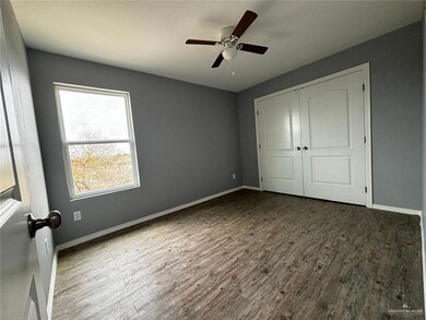 Unfurnished bedroom featuring ceiling fan, a closet, baseboards, and wood finished floors