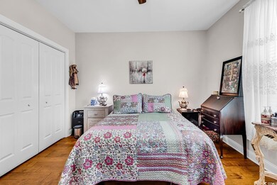Bedroom featuring a closet, wood finished floors, baseboards, and ceiling fan