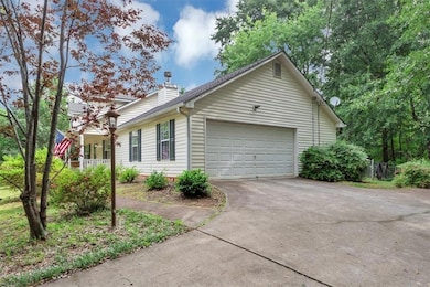 View of home's exterior featuring driveway, an attached garage, and a chimney