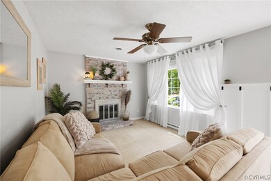 Living room featuring ceiling fan, brick wall, a t