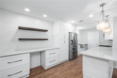 Kitchen featuring open shelves, light stone counters, tasteful backsplash, white cabinets, and recessed lighting
